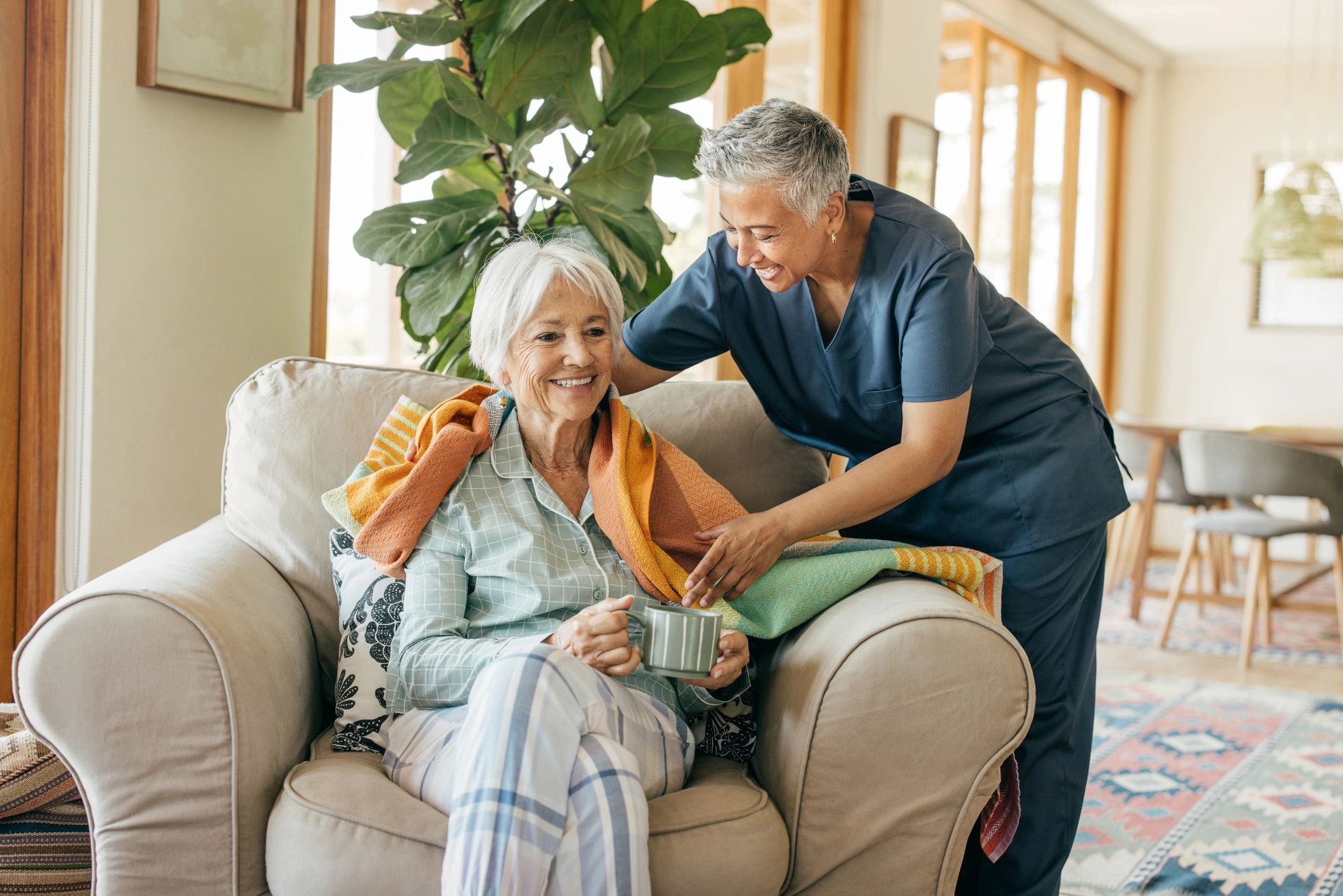 A resident being greeted warmly in a bright, comfortable living room